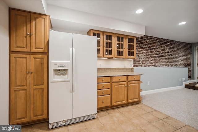 1240 Girard St NW, Washington, DC 20009 - kitchen with white fridge with ice dispenser, brick wall, brown cabinets, glass insert cabinets, and light colored carpet