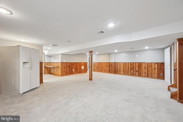 814 Manhattan Beach Rd, Severna Park, MD 21146 - finished basement featuring white refrigerator with ice dispenser, wooden walls, a wainscoted wall, light carpet, and stairway
