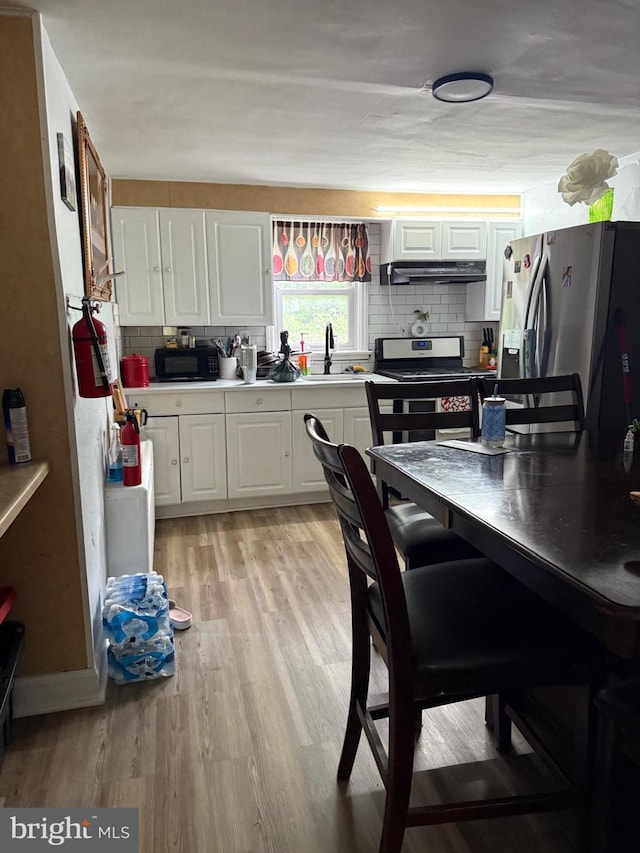 2212 Cove Rd, Pennsauken, NJ 08110 - kitchen featuring stainless steel appliances, light wood-style floors, white cabinets, light countertops, and decorative backsplash