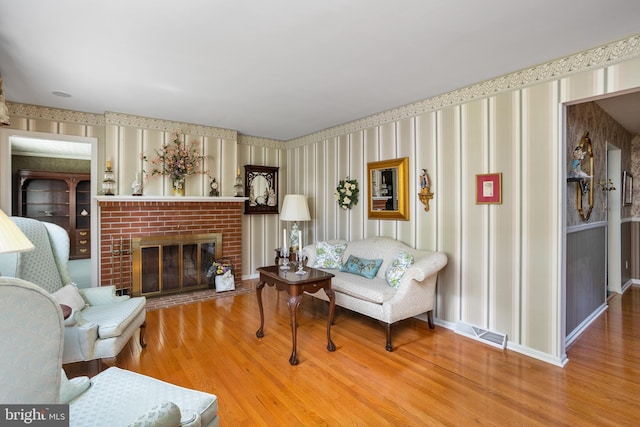 3847 Quakerbridge Rd, Hamilton, NJ 08619 - living room featuring wallpapered walls, wood finished floors, and a brick fireplace