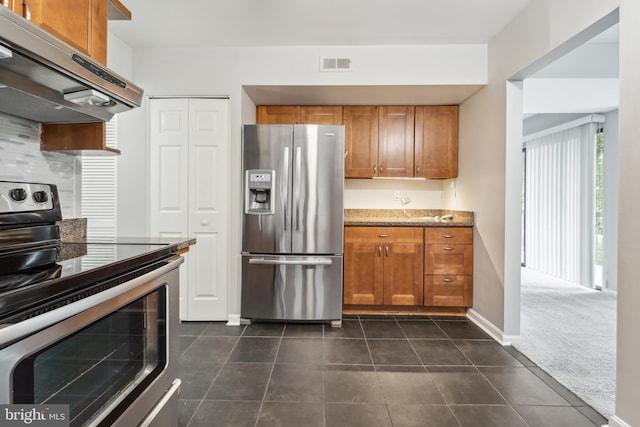 9810 Kingsbridge Dr Unit 102, Fairfax, VA 22031 - kitchen featuring stainless steel appliances, extractor fan, brown cabinets, and stone countertops