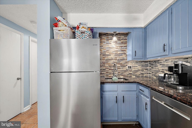 14 136th St Unit 101, Ocean City, MD 21842 - kitchen featuring stainless steel appliances, backsplash, a textured ceiling, blue cabinetry, and light tile patterned floors