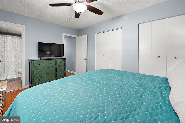 14 136th St Unit 101, Ocean City, MD 21842 - bedroom with multiple closets, wood finished floors, a ceiling fan, ensuite bath, and a textured ceiling