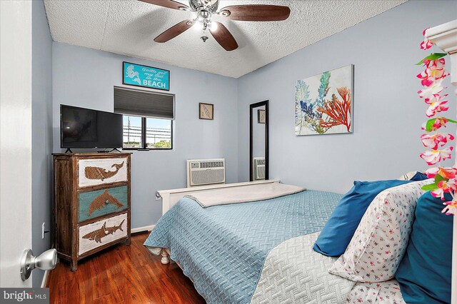 14 136th St Unit 101, Ocean City, MD 21842 - bedroom featuring wood finished floors, a wall mounted AC, a textured ceiling, and ceiling fan