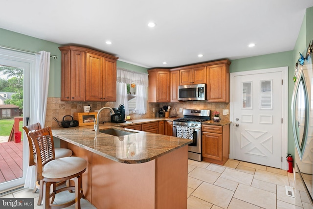 478 Alexander Ave, Maple Shade, NJ 08052 - kitchen featuring appliances with stainless steel finishes, a peninsula, stone countertops, brown cabinets, and recessed lighting