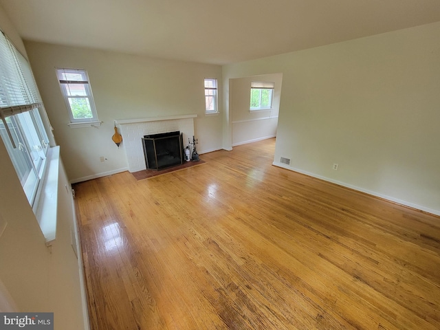 142 Fleetwood Ter, Silver Spring, MD 20910 - unfurnished living room featuring a fireplace, light wood-style floors, and plenty of natural light