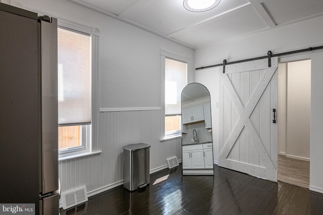 16 S 2nd St, Womelsdorf, PA 19567 - spare room with a barn door, dark wood-style floors, and a wainscoted wall