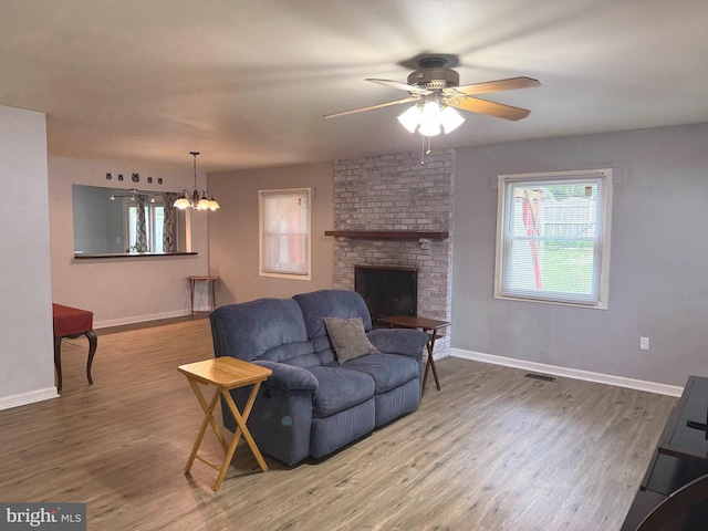 52 Henderson Ln, Willingboro, NJ 08046 - living room with wood finished floors, ceiling fan, a chandelier, and a fireplace