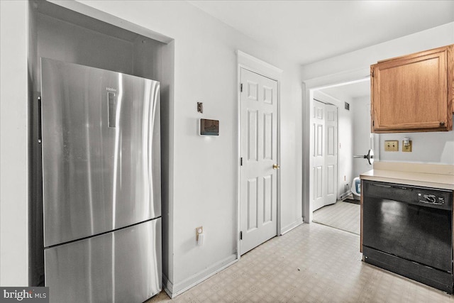 606 Knightsbridge Dr, Hagerstown, MD 21740 - kitchen with freestanding refrigerator, black dishwasher, light floors, light countertops, and brown cabinetry