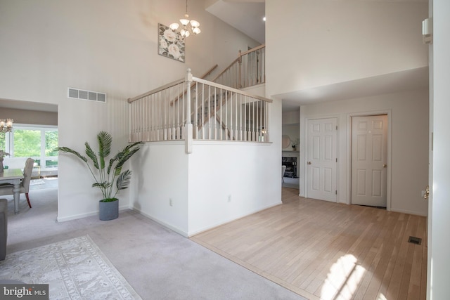 505 Country Pointe Cir, Perkasie, PA 18944 - unfurnished living room with a chandelier, a high ceiling, a fireplace, hardwood / wood-style flooring, and carpet floors