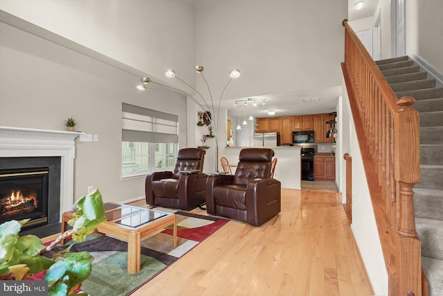 2044 Astilbe Way Unit 2044, Odenton, MD 21113 - living room featuring stairs, a glass covered fireplace, and light wood finished floors