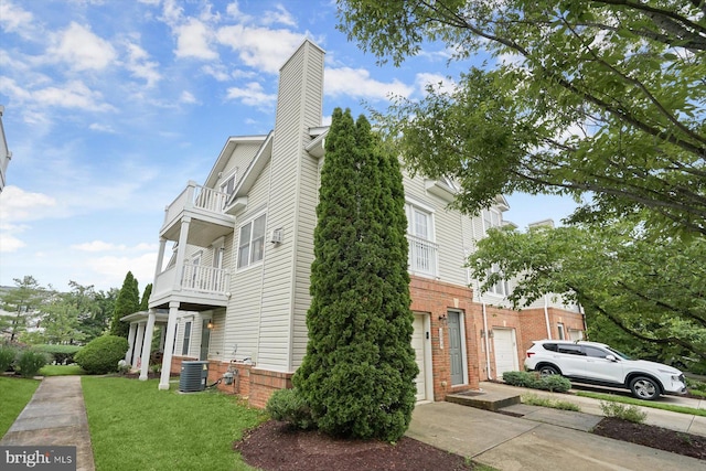 2044 Astilbe Way Unit 2044, Odenton, MD 21113 - view of property exterior with a balcony, a chimney, a yard, driveway, and brick siding