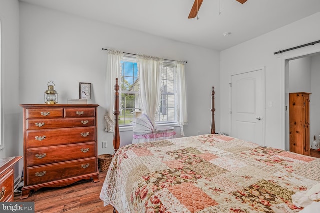 9434 Winchester Ave, Bunker Hill, WV 25413 - bedroom featuring wood finished floors, a barn door, and a ceiling fan