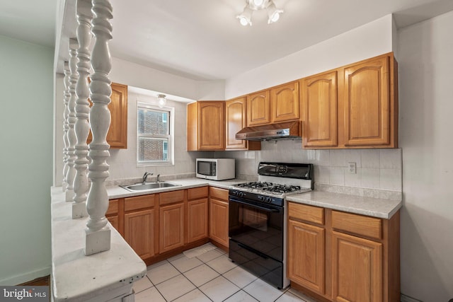 1329 Barnett St, Philadelphia, PA 19111 - kitchen featuring black gas stove, under cabinet range hood, backsplash, light countertops, and light tile patterned flooring