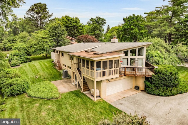 10135 Spring Pools Ln, Columbia, MD 21044 - back of house with a sunroom, stairs, asphalt driveway, a wooden deck, and a lawn