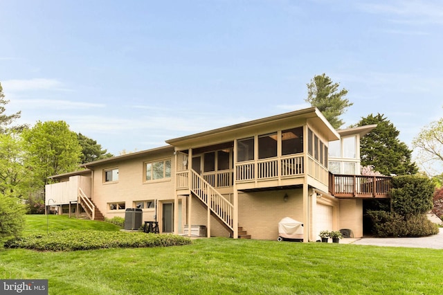 10135 Spring Pools Ln, Columbia, MD 21044 - back of property with a sunroom, stairs, a garage, a lawn, and driveway
