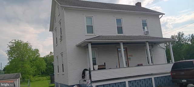 106 Center St, Manns Choice, PA 15550 - view of front facade with covered porch, a chimney, and cooling unit