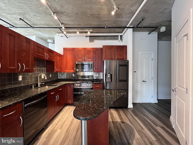 301 Massachusetts Ave NW Unit 301, Washington, DC 20001 - kitchen featuring appliances with stainless steel finishes, light wood-type flooring, track lighting, dark brown cabinets, and backsplash