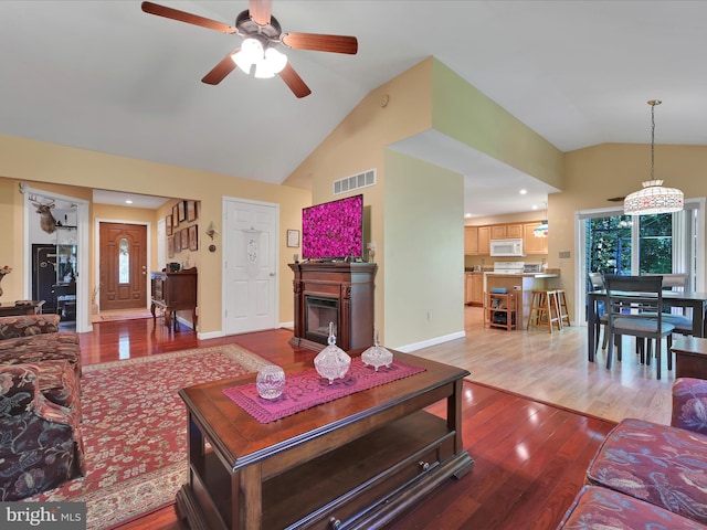 2528 Papoose Dr, Auburn, PA 17922 - living room featuring wood finished floors, a ceiling fan, a glass covered fireplace, high vaulted ceiling, and recessed lighting
