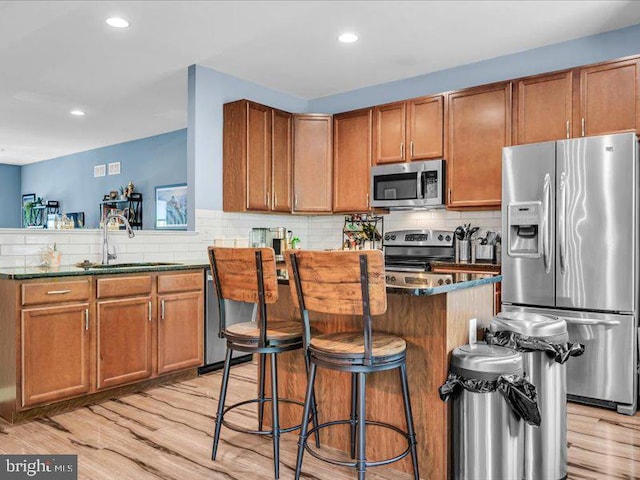 44 Munro Rd, Newark, DE 19711 - kitchen with appliances with stainless steel finishes, tasteful backsplash, light wood-type flooring, a center island, and brown cabinetry