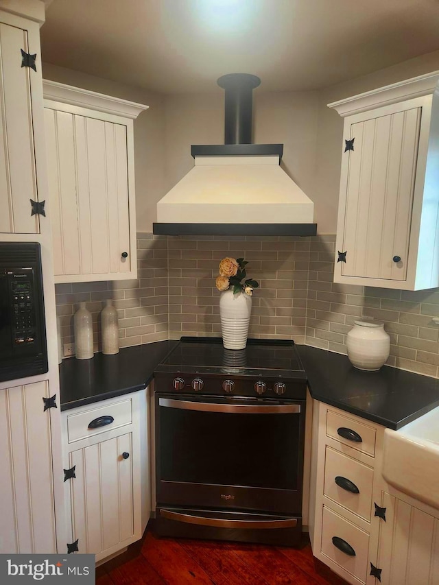 2569 White Oak Rd, Strasburg, PA 17579 - kitchen with stainless steel electric range oven, black microwave, premium range hood, dark countertops, and white cabinets