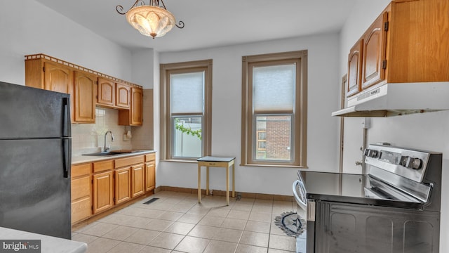 501 W 4th St, Bethlehem, PA 18015 - kitchen featuring stainless steel electric range oven, freestanding refrigerator, under cabinet range hood, backsplash, and light countertops