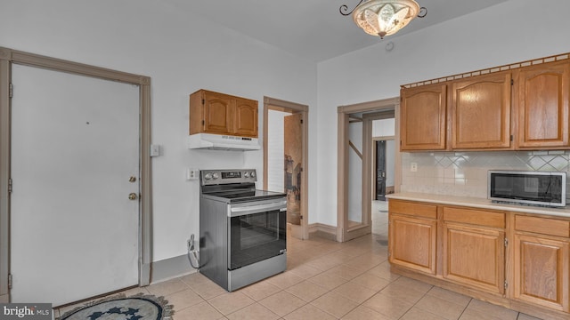 501 W 4th St, Bethlehem, PA 18015 - kitchen featuring stainless steel range with electric cooktop, under cabinet range hood, light countertops, tasteful backsplash, and light tile patterned floors