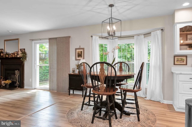 12513 Dardanelle Ct, Herndon, VA 20170 - dining space with light wood finished floors, a chandelier, and a fireplace