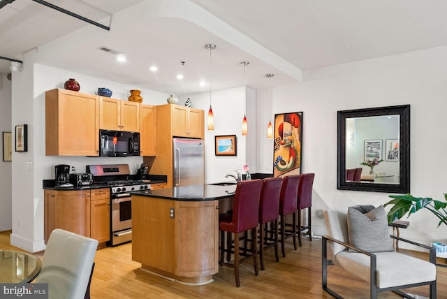 2328 Champlain St NW Unit 101, Washington, DC 20009 - kitchen with appliances with stainless steel finishes, dark countertops, light wood-style floors, a kitchen breakfast bar, and recessed lighting