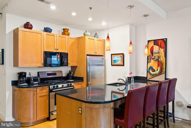 2328 Champlain St NW Unit 101, Washington, DC 20009 - kitchen with appliances with stainless steel finishes, a breakfast bar, light wood-style floors, recessed lighting, and pendant lighting