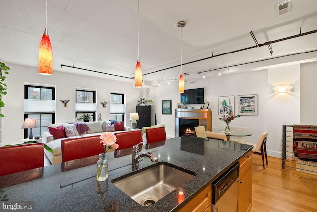 2328 Champlain St NW Unit 101, Washington, DC 20009 - kitchen featuring stainless steel dishwasher, open floor plan, light wood-type flooring, and decorative light fixtures