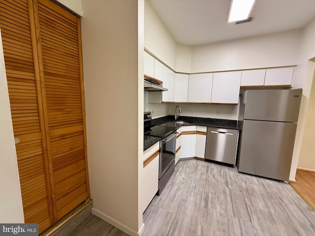 301 Byberry Rd Unit H10, Philadelphia, PA 19116 - kitchen featuring stainless steel appliances, under cabinet range hood, white cabinets, light wood-style floors, and dark countertops