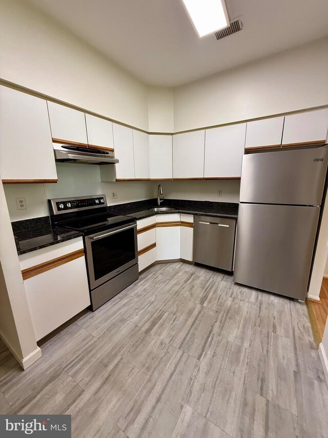 301 Byberry Rd Unit H10, Philadelphia, PA 19116 - kitchen with stainless steel appliances, under cabinet range hood, white cabinets, and light wood finished floors