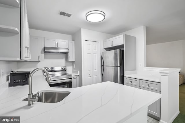 20 Deer Run Ct Unit D, Baltimore, MD 21227 - kitchen featuring stainless steel appliances, under cabinet range hood, a peninsula, light stone countertops, and gray cabinets