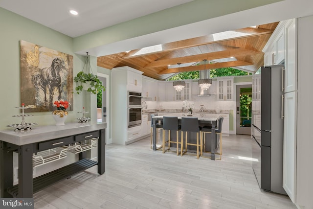 11726 Lariat Ln, Oakton, VA 22124 - kitchen with wooden ceiling, stainless steel appliances, white cabinetry, a breakfast bar area, and a center island