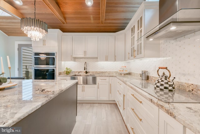 11726 Lariat Ln, Oakton, VA 22124 - kitchen featuring wall chimney exhaust hood, double oven, a wooden ceiling with exposed beams, white cabinetry, and hanging light fixtures