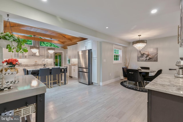 11726 Lariat Ln, Oakton, VA 22124 - kitchen with freestanding refrigerator, white cabinetry, a chandelier, decorative backsplash, and decorative light fixtures