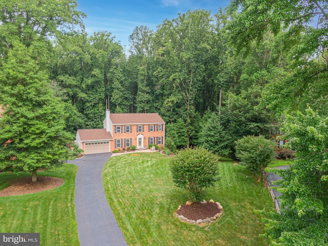 11726 Lariat Ln, Oakton, VA 22124 - colonial inspired home featuring a front yard, asphalt driveway, an attached garage, and a forest view