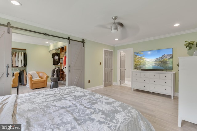 11726 Lariat Ln, Oakton, VA 22124 - bedroom featuring a barn door, crown molding, light wood-style flooring, recessed lighting, and a walk in closet