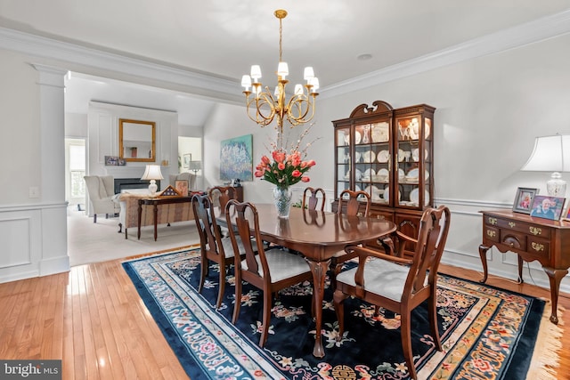 14 Mcconkey Dr, Washington Crossing, PA 18977 - dining room with a chandelier, a fireplace, ornamental molding, a wainscoted wall, and wood-type flooring
