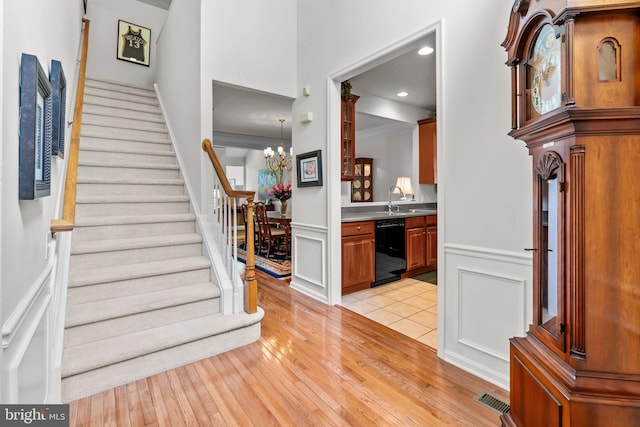 14 Mcconkey Dr, Washington Crossing, PA 18977 - entryway featuring light wood-style floors, stairs, a decorative wall, a chandelier, and a wainscoted wall