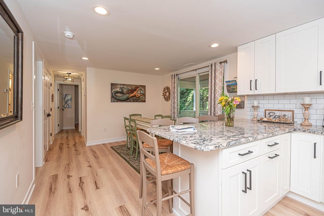 120 Robin Hood, Ocean Pines, MD 21811 - kitchen featuring light wood finished floors, white cabinetry, a peninsula, a breakfast bar, and recessed lighting