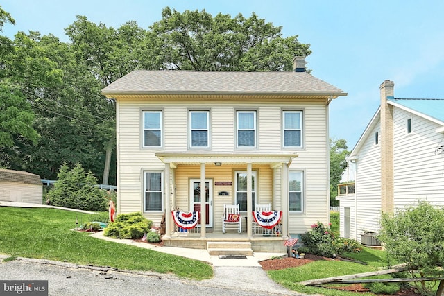 75 Railroad Ave, York Haven, PA 17370 - view of front facade featuring a porch, a front yard, a chimney, and an outdoor structure