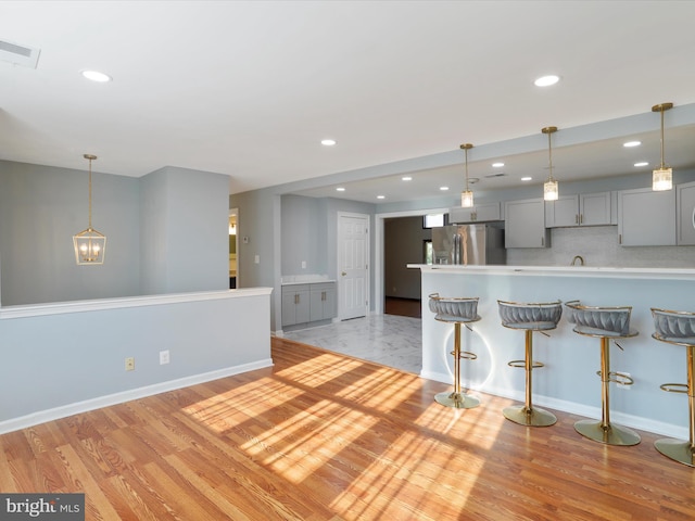 8175 Stone Bridge Rd, Greencastle, PA 17225 - kitchen with stainless steel fridge with ice dispenser, gray cabinetry, a breakfast bar, recessed lighting, and pendant lighting
