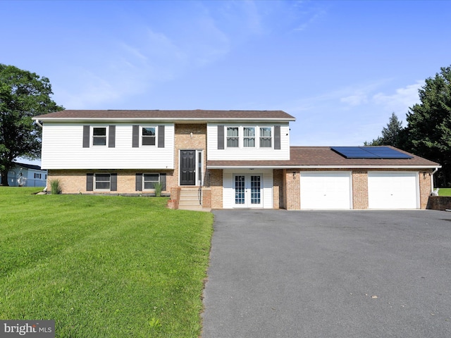 8175 Stone Bridge Rd, Greencastle, PA 17225 - bi-level home featuring french doors, a front yard, an attached garage, driveway, and roof mounted solar panels