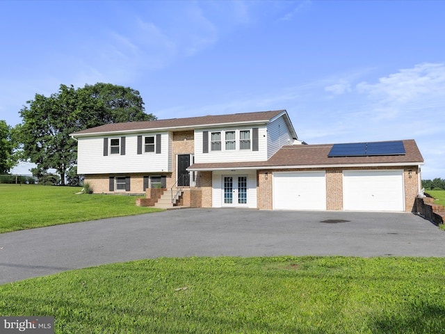 8175 Stone Bridge Rd, Greencastle, PA 17225 - split foyer home featuring brick siding, driveway, a garage, and roof mounted solar panels