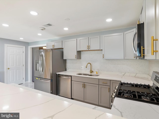 8175 Stone Bridge Rd, Greencastle, PA 17225 - kitchen with appliances with stainless steel finishes, light stone countertops, gray cabinets, decorative backsplash, and recessed lighting