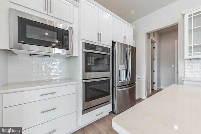 15429 Solomon Way, Lewes, DE 19958 - kitchen with appliances with stainless steel finishes, tasteful backsplash, white cabinetry, wood finished floors, and glass insert cabinets