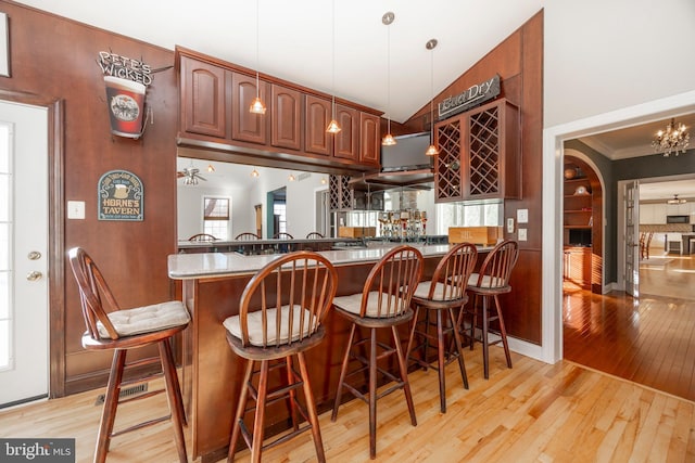 1021 Mulberry St, Chester Springs, PA 19425 - kitchen with light wood finished floors, a breakfast bar area, a peninsula, hanging light fixtures, and stone countertops