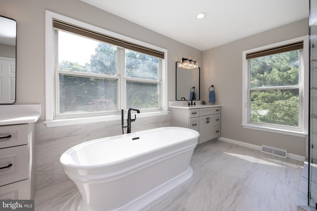 1021 Mulberry St, Chester Springs, PA 19425 - bathroom with vanity, marble tiled flooring, plenty of natural light, a soaking tub, and recessed lighting